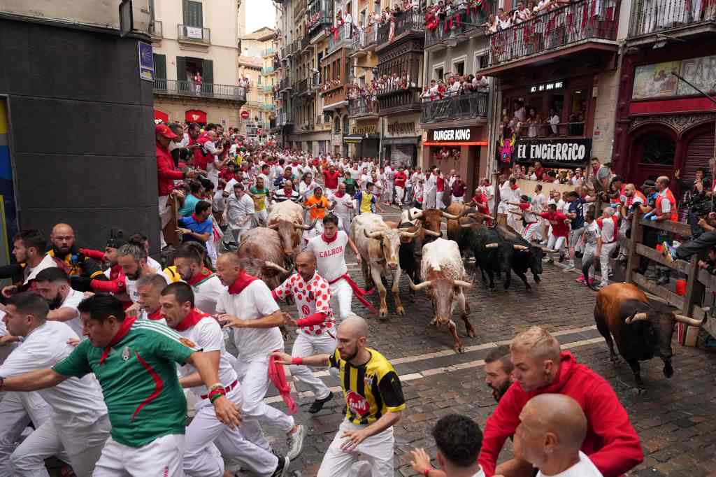 People participating in the famous running of the bulls in the streets of Pamplona on the first day of the festival.