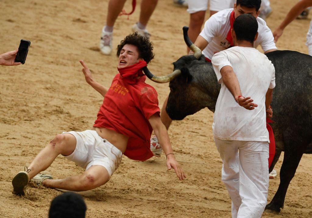 A bull picking up a participant by his scarf.