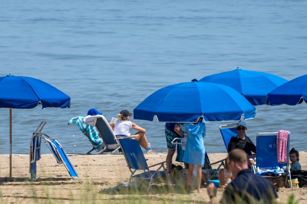 President Joe Biden, seated at left in a blue baseball cap, sits with first lady Jill Biden.