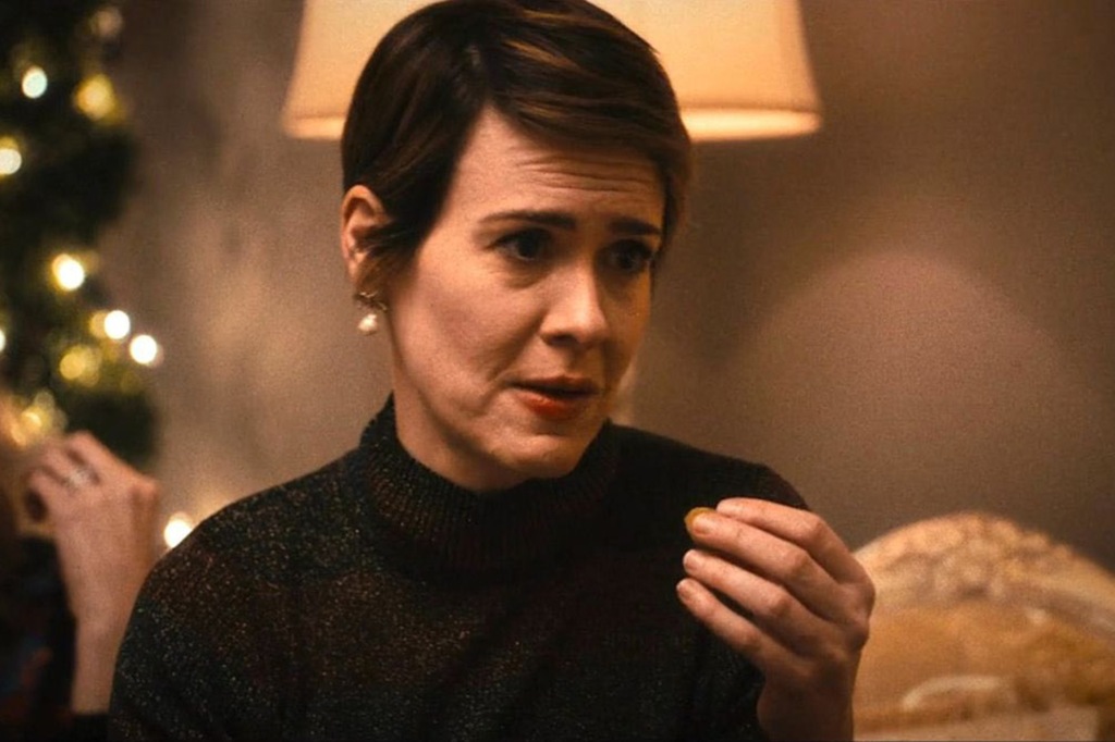 Sarah Paulson sits at the dinner table with a concerned look.