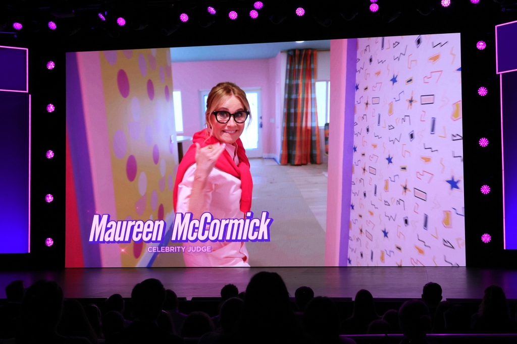 Maureen McCormick in glasses, standing in a hall. 
