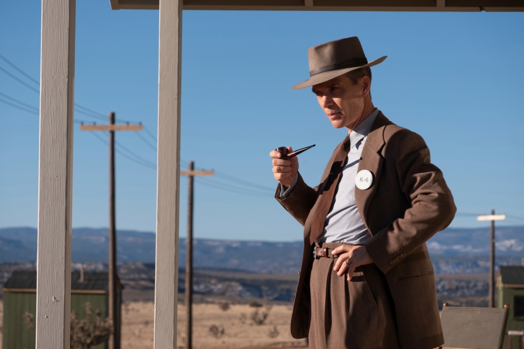 Cillian Murphy in a bowler hat smoking a pipe. 