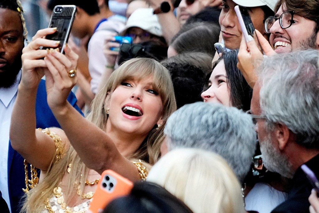 Swift poses for a selfie with fans.