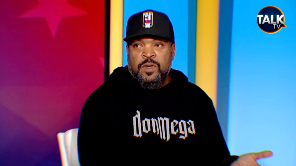 Ice Cube wearing a hat talking. 