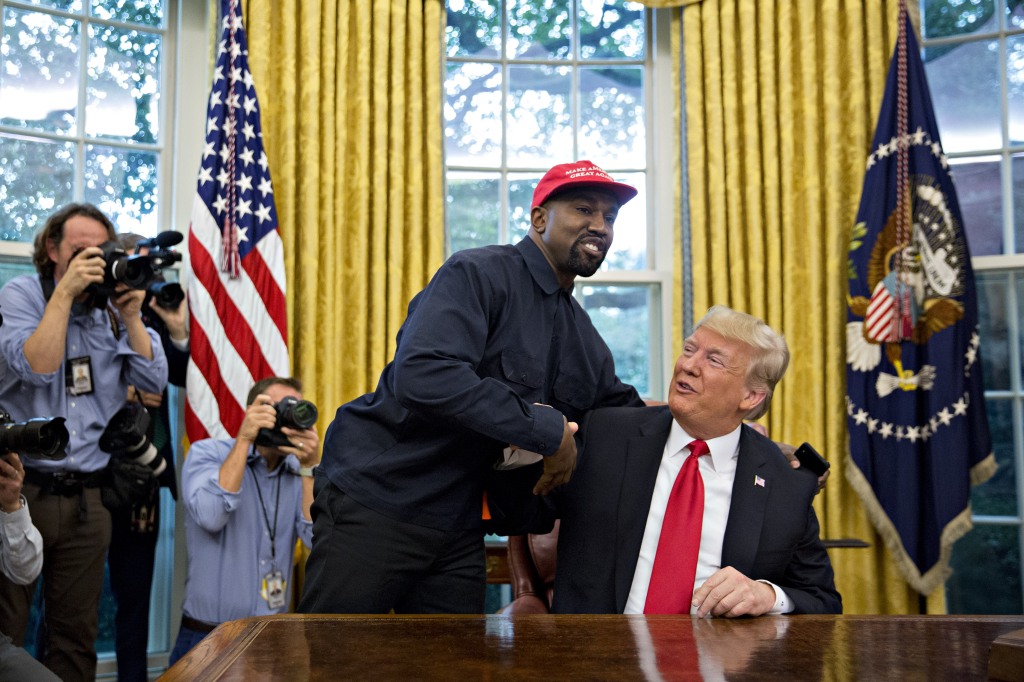 Kanye West smiling with Donald Trump. 