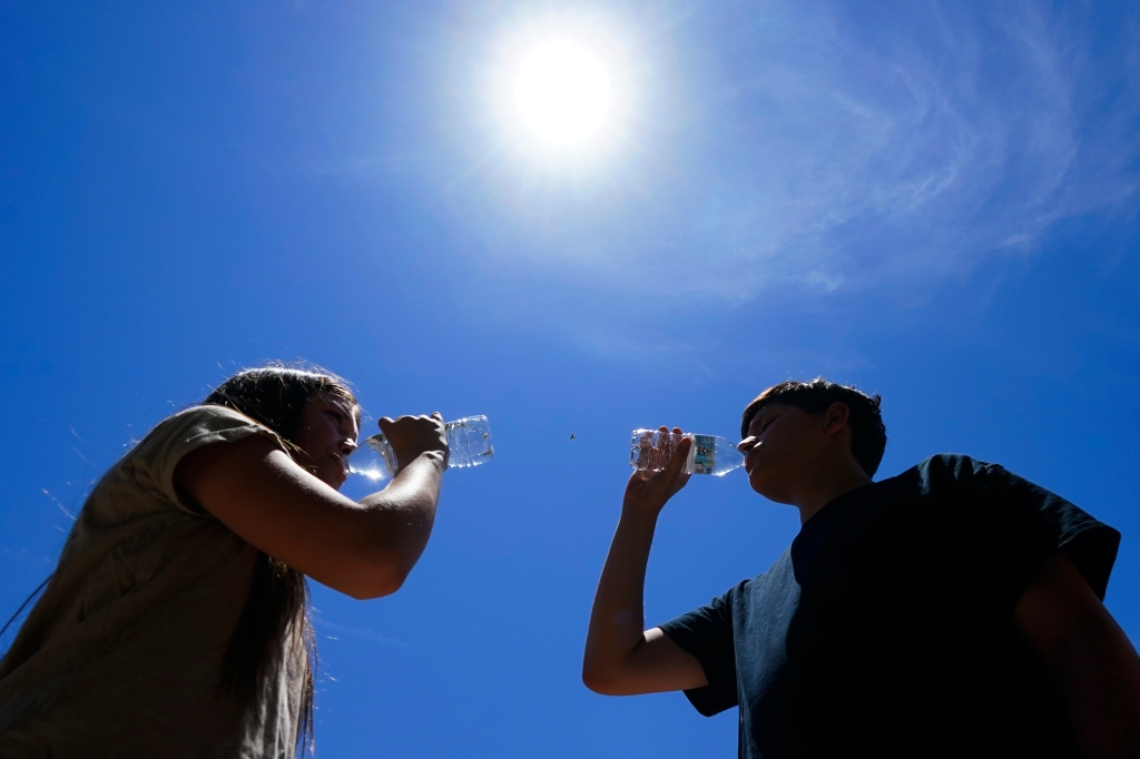 Two Phoenix residents drink water as temperatures are expected to hit 115 degreesin Phoenix on Monday, July 17, 2023.