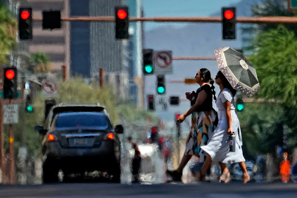 Heat ripples engulf two ladies while crossing the street in downtown Phoenix.