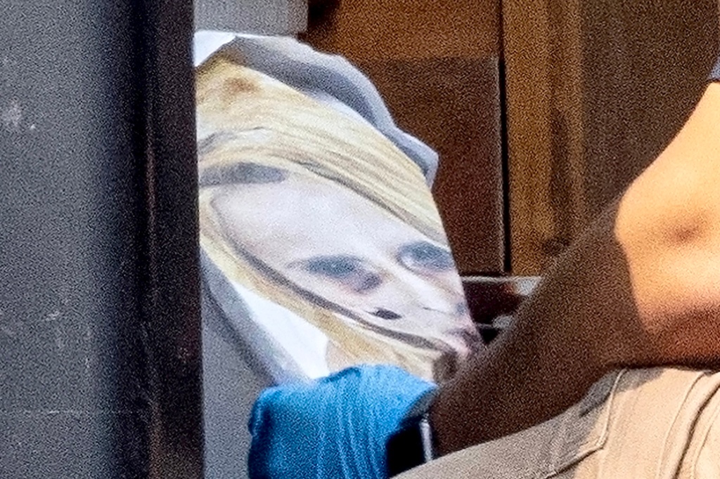 CSI looking at a drawing of a woman with two bruised eyes removed from the home of Rex Heuermann