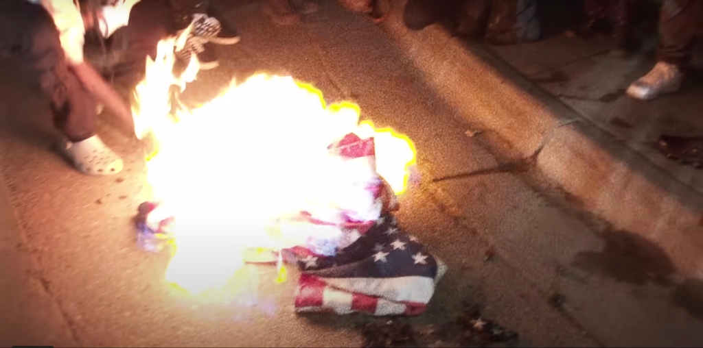 Flag burning on the ground