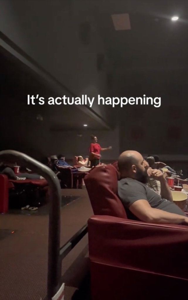 An employee tells patrons the light in a movie theatre are not working.