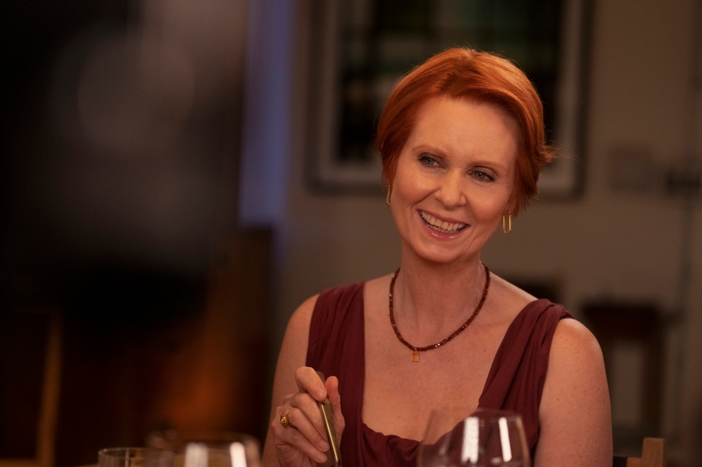 Miranda Hobbes smiles at dinner on "And Just Like That." 