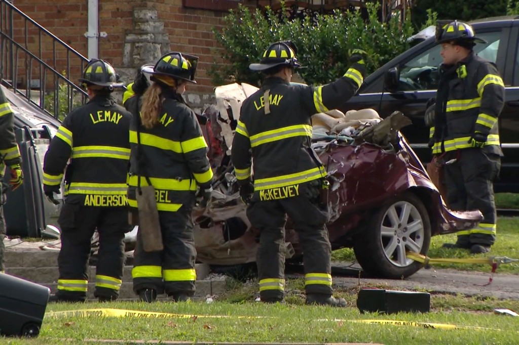 Firefighters were seen standing by the remains of the car. 