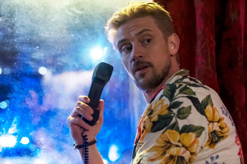 Boyd Holbrook holding a phone looking serious. 