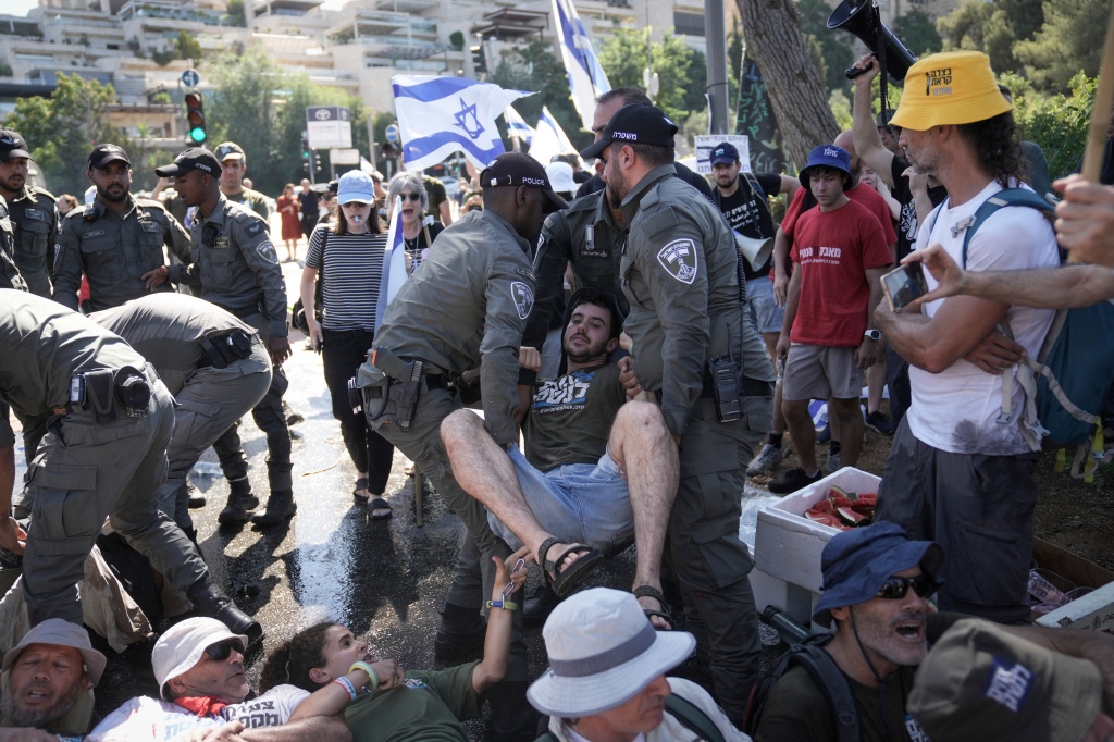 Israeli police disperse demonstrators blocking the road leading to the Knesset.