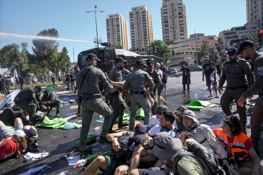 Israeli police disperse demonstrators blocking the road leading to the Knesset, Israel's parliament.