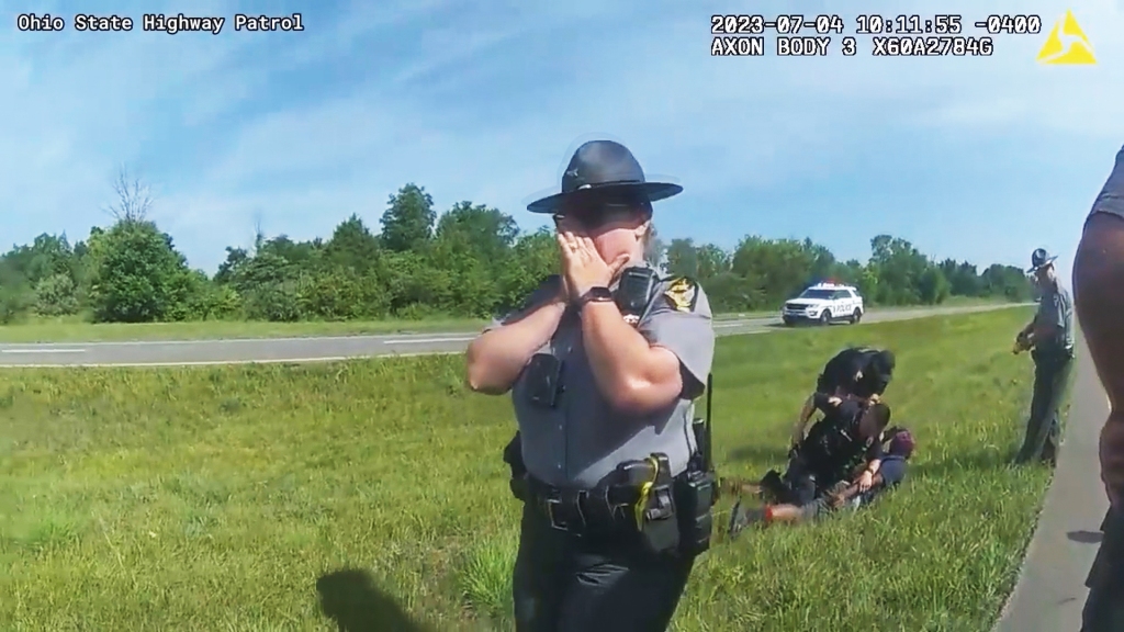 Officer looks shocked as arrest takes place in the background