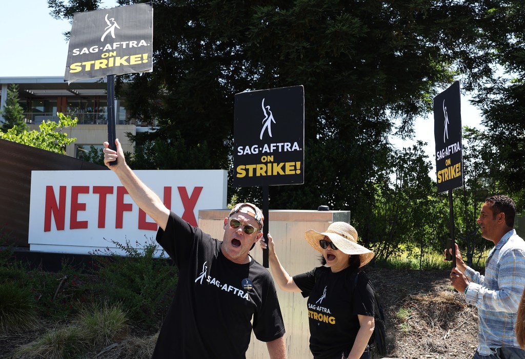 Members of SAG-AFTRA hold signs as they picket in front of Netflix headquarters on July 20, 2023 in Los Gatos, California. 