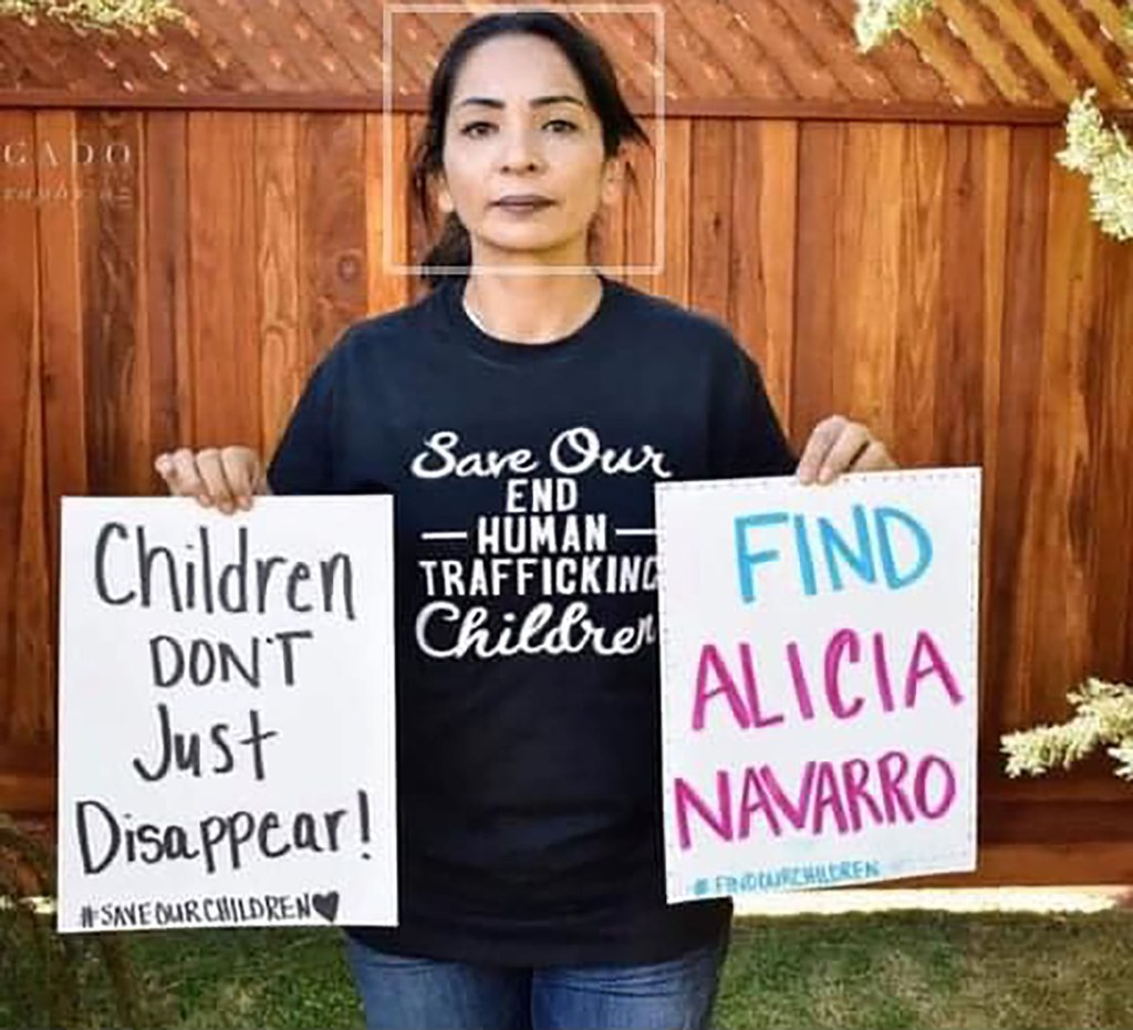 Nuñez holding signs asking for help to find her daughter. 