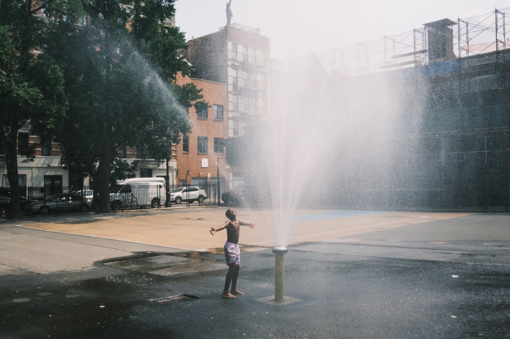 A little boy cooling down at a sprinkler in Manhattan's East Village on July 27, 2023.