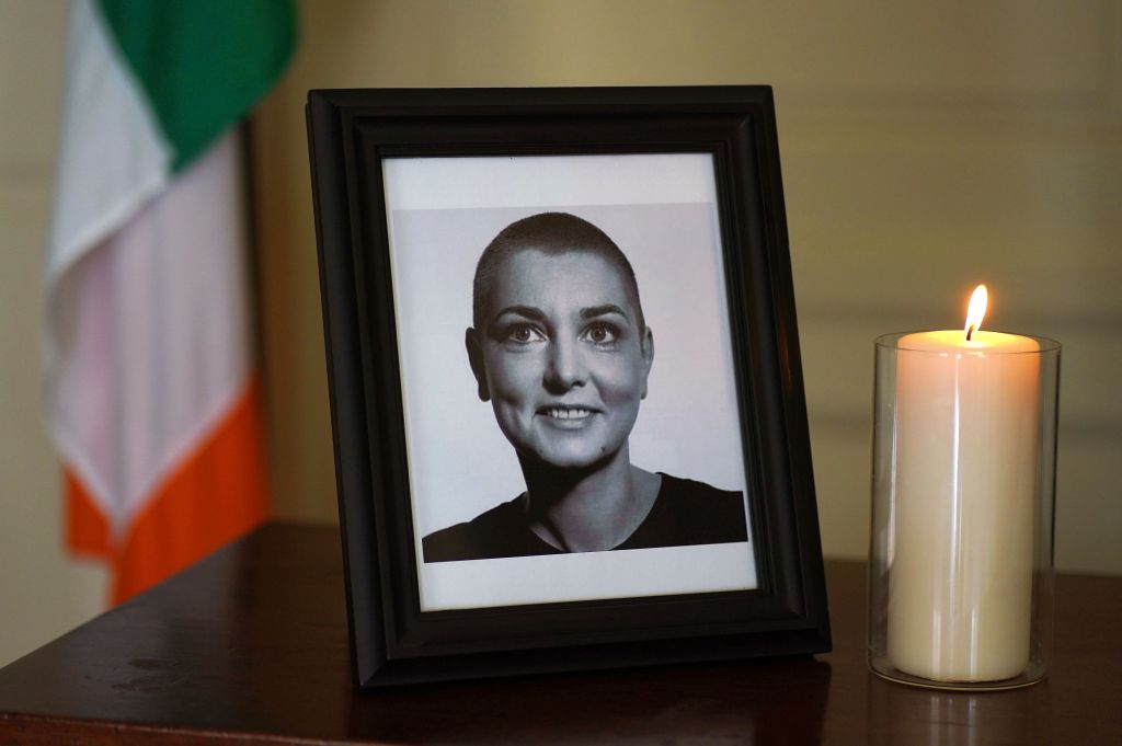 A photo of Sinead O'Connor in a frame next to a candle. 