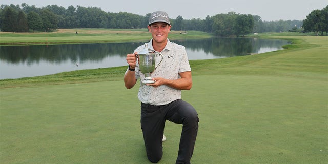 Vincent Norrman kneels with trophy