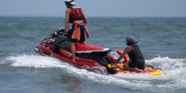 New York lifeguards ride a jet ski during a shark patrol run