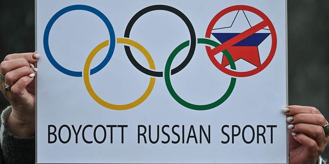 Protester holds a 'Boycott Russian Sport' sign