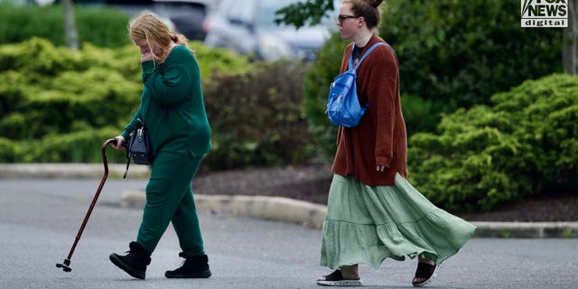 Rex Heuermann's wife, Asa Ellerup and daughter, Victoria Heuermann walk on the street