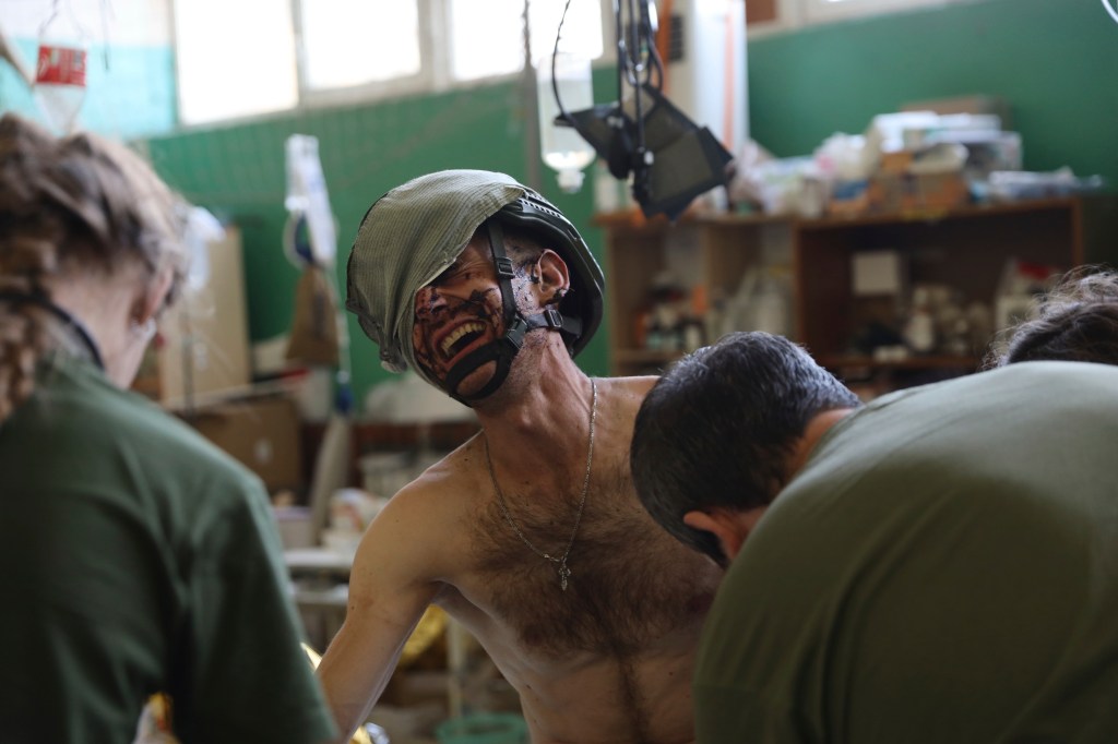 Medics help an injured Ukrainian serviceman in a frontline medical stabilization point in the Zaporizhzhia region. 