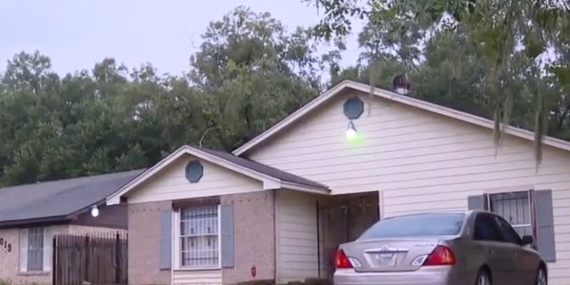 Beige house with a car parked outside.