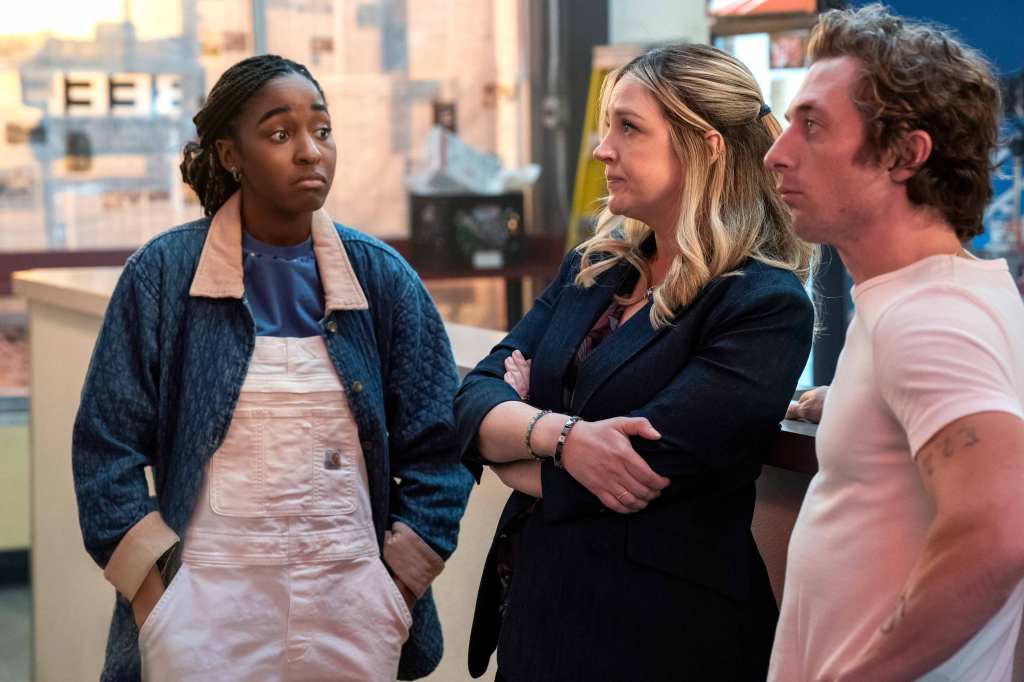 Ayo Edibiri, Abby Elliott and Jeremy Allen White as Sydney, Natalie and Carmey. They're standing side-by-side inside the restaurant, which is being renovated. Sydney has her hands in her pockets, Natalie looks worried and Carmey is staring off into space.