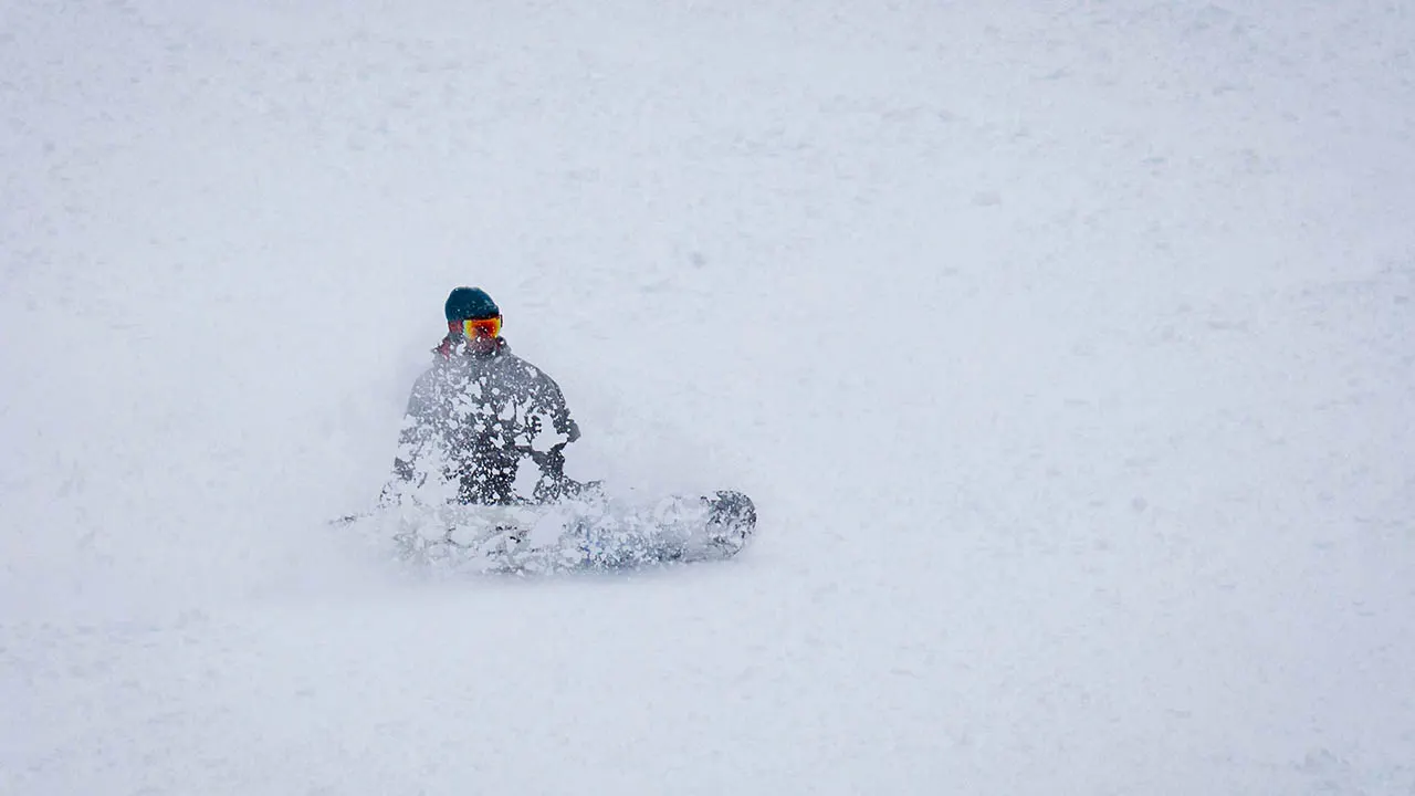 A snowboarder goes down a hill