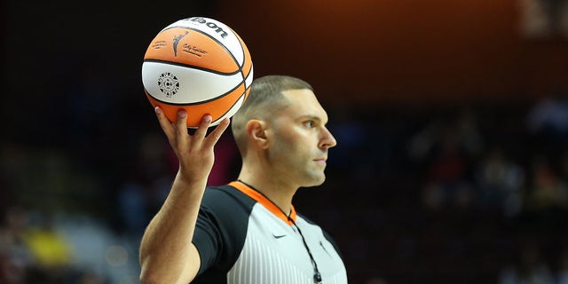 WNBA ref holds the ball