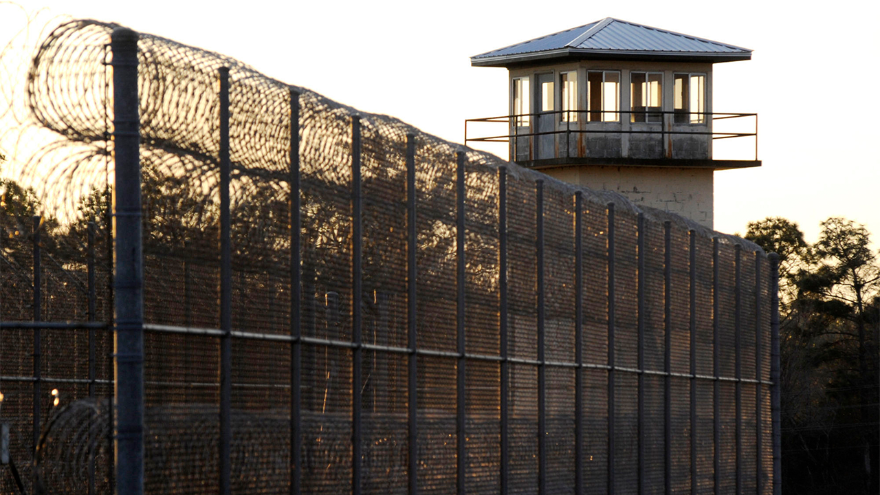 Sun setting behind prison fence