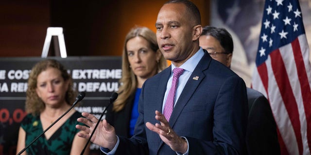 US House Minority Leader Hakeem Jeffries speaks at a podium with other members of House Democratic leadership standing beside him