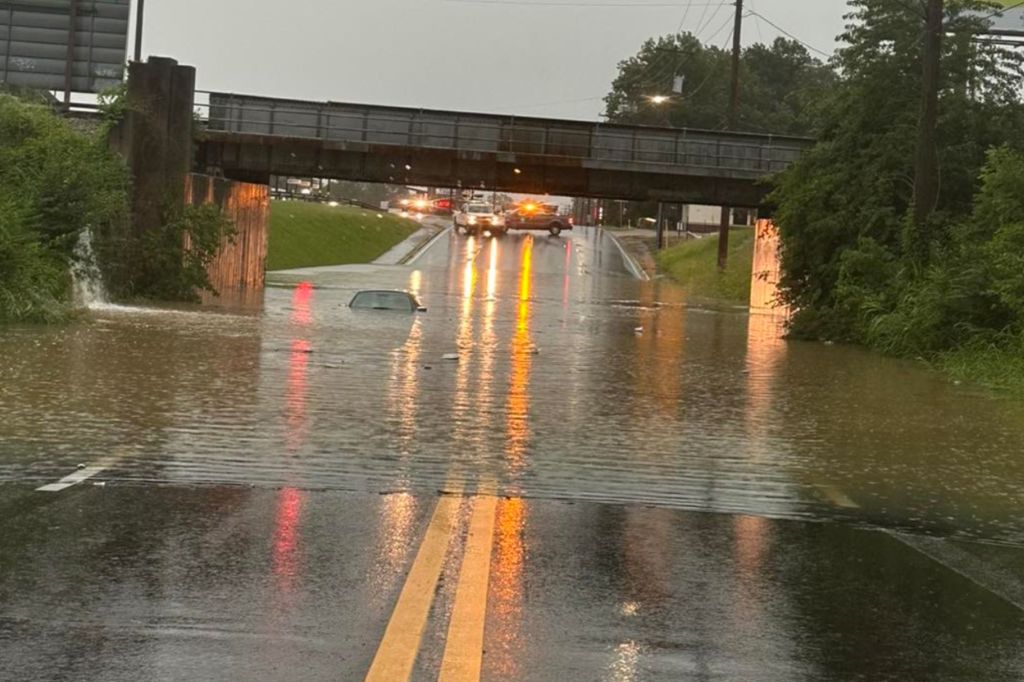 Roadways are seen flooded and a car is submerged in water in Paducah, Kentucky, on Wednesday, July 19, 2023.
