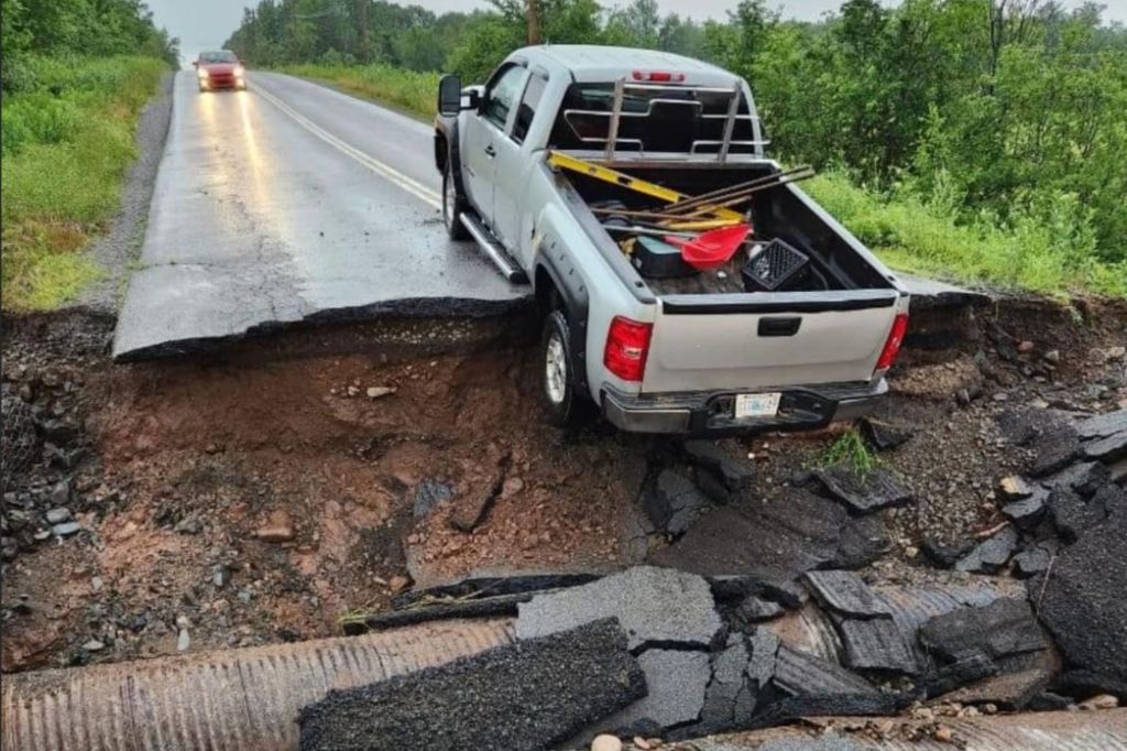 A truck is seen hanging off a crumbling roadway in the aftermath of the flooding in Nova Scotia. 