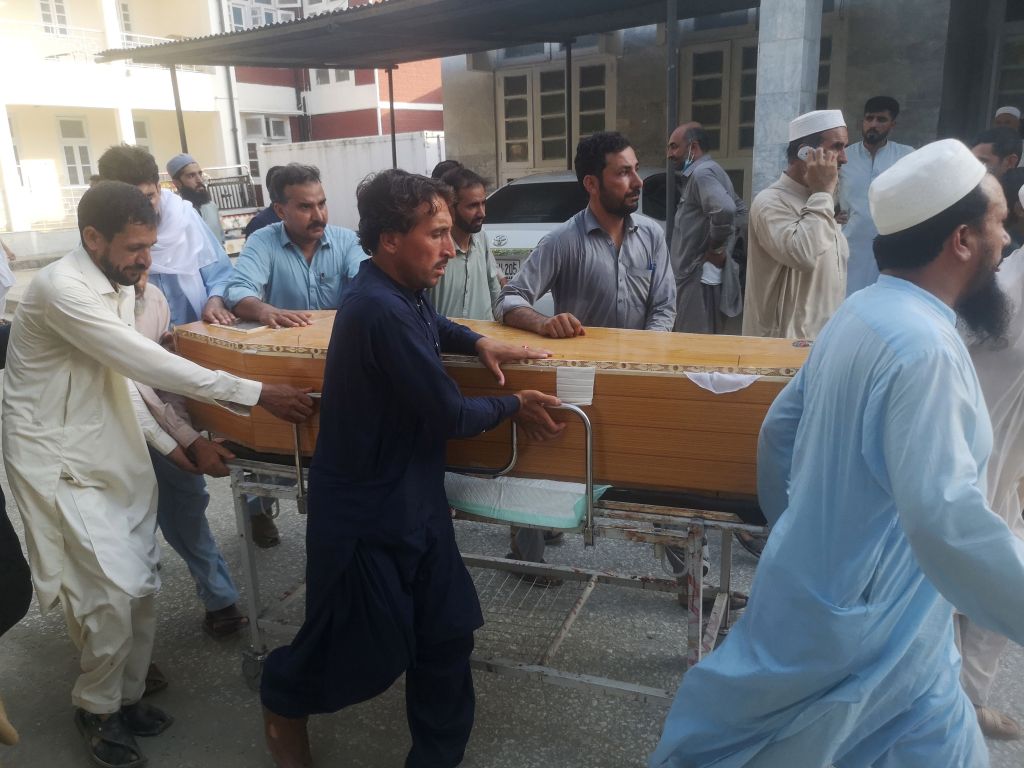 People shift coffins outside a hospital following a blast targeting a gathering of Islamic political party Jamiat Ulma-e-Islam (JUI-F) in Bajaur, Pakistan on July 30, 2023.