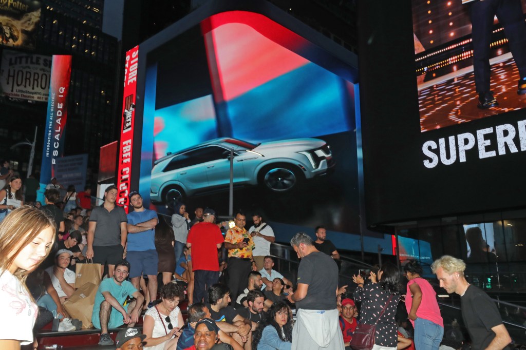 The new Cadillac car reveal advertisement flashes above people in Times Square New York on August 9, 2023. 