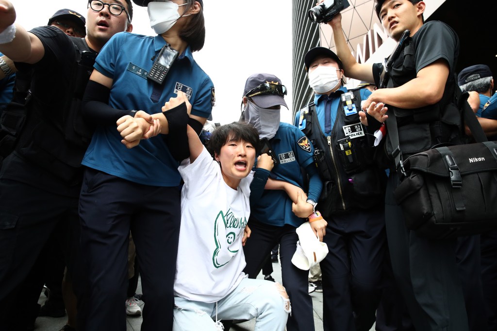 A South Korean university student is detained by police officers on an attempt to break into the Japanese embassy on Aug. 24, 2023 in Seoul. 