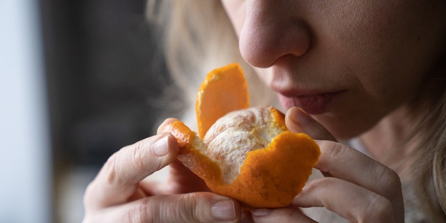 Woman smelling orange