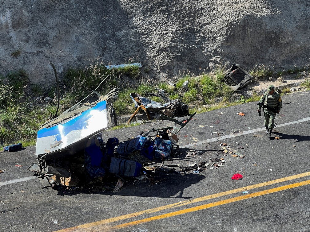 A soldier walks by a part of the wreckage of a bus at the area of the accident in Tepelmeme Villa de Morelos, Mexico on Aug. 22, 2023. 