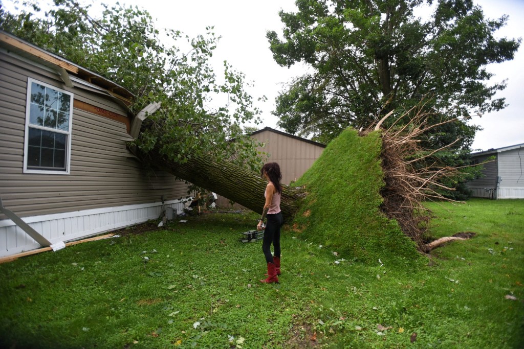 Ashley Lovejoy surveys the damage after a tree fell on the bedroom of her home in Webberville, Michigan, U.S., August 25, 2023 after a violent storm and tornado swept through Ingham County the previous night. 