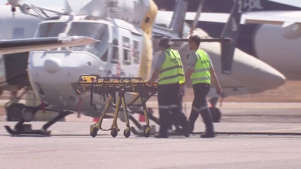 Paramedics push a stretcher on the tarmac in Darwin, Australia on August 27.