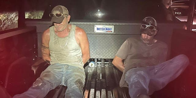 Casey Judd Howe and other arrested suspect in back of truck