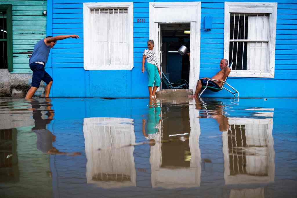 Residents in Batabano, Cuba remain outside their house in a flooded neighborhood after Hurricane Idalia approached the island on Monday.