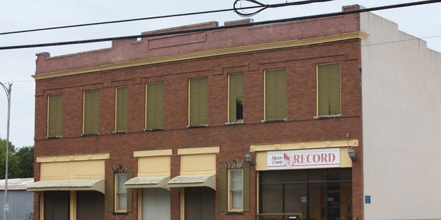 The Marion County Record headquarters, a two-story brick building with blinds and curtains closed