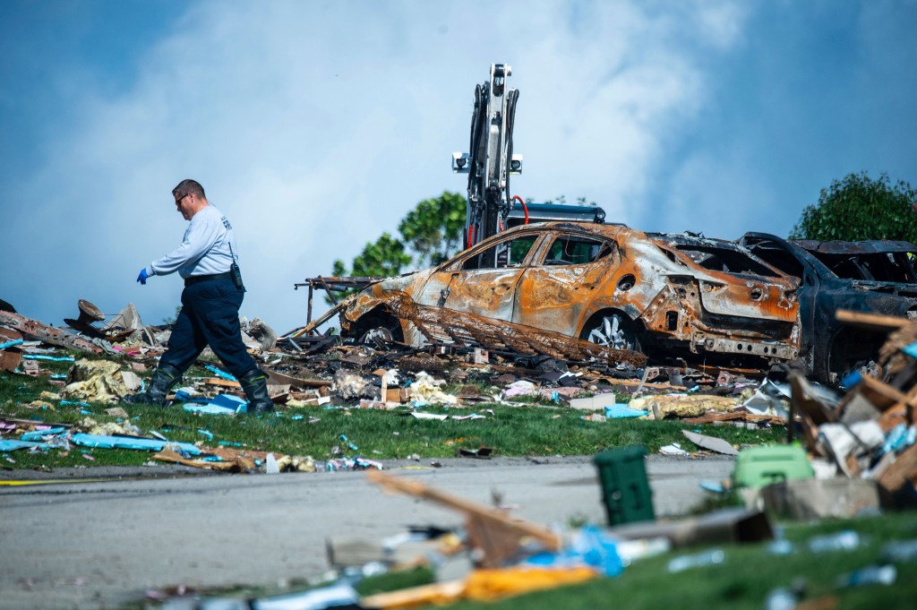 An investigator walks through the debris from a home explosion on Aug. 13, 2023, which occurred the day before in Plum, Pa. 
