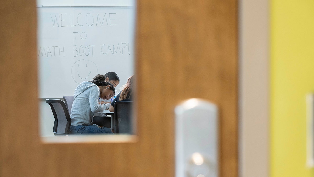 Student in a classroom, behind a door