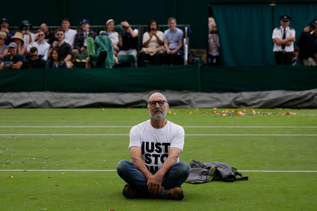 A Just Stop Oil protester sits on Court 18 on day three of the Wimbledon tennis championships in London, on July 5, 2023. 